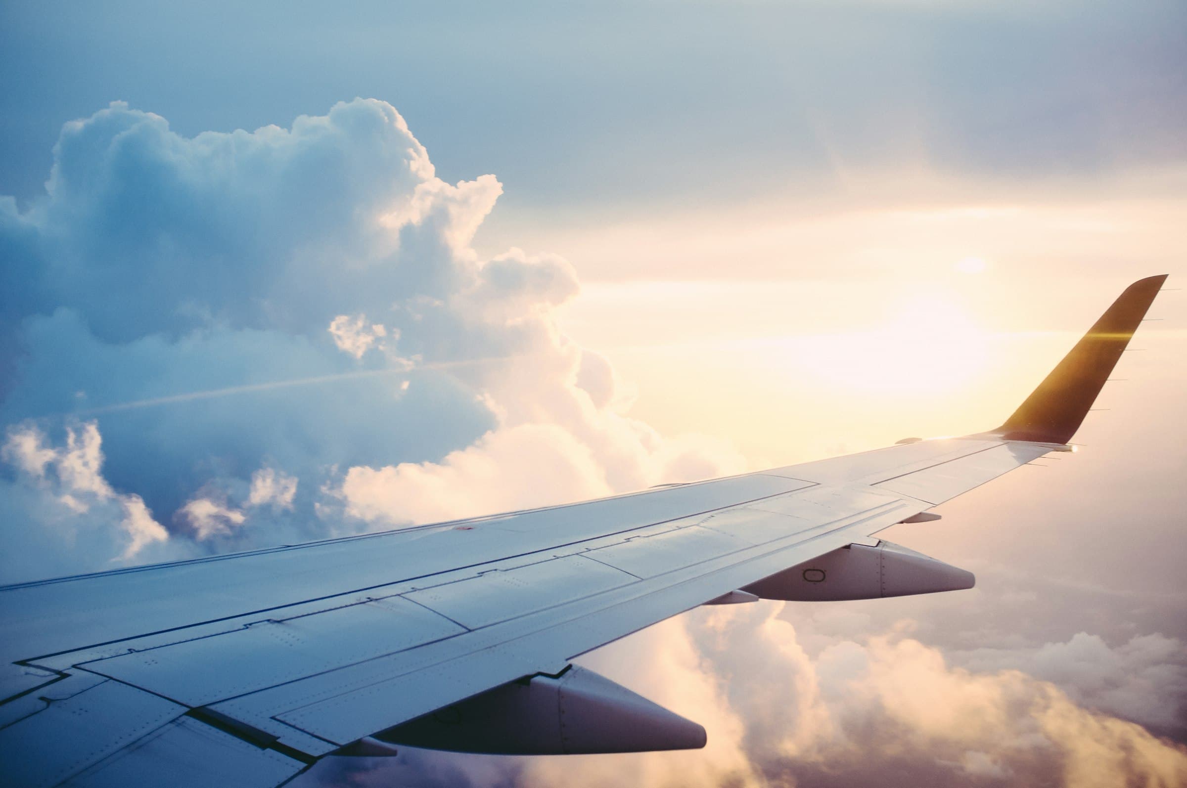 An aircraft wing above the clouds at sunrise